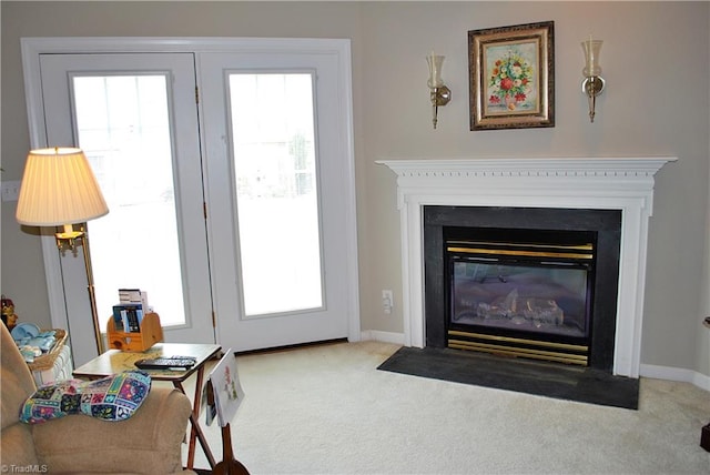 living area featuring carpet flooring, baseboards, a fireplace with flush hearth, and a healthy amount of sunlight