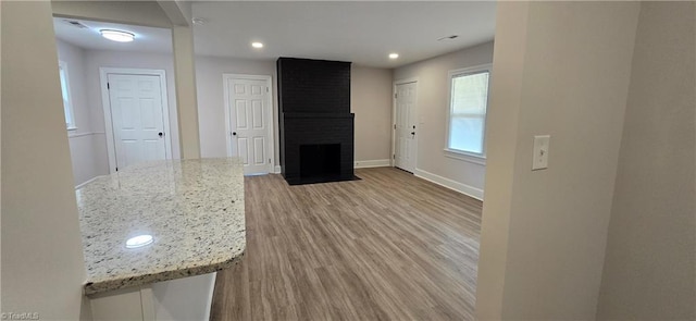 unfurnished room featuring a fireplace and light hardwood / wood-style floors