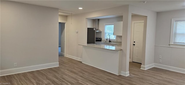 kitchen with dark hardwood / wood-style flooring, light stone countertops, sink, and white cabinets