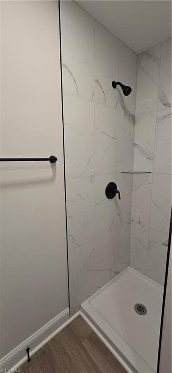 bathroom featuring hardwood / wood-style floors and tiled shower