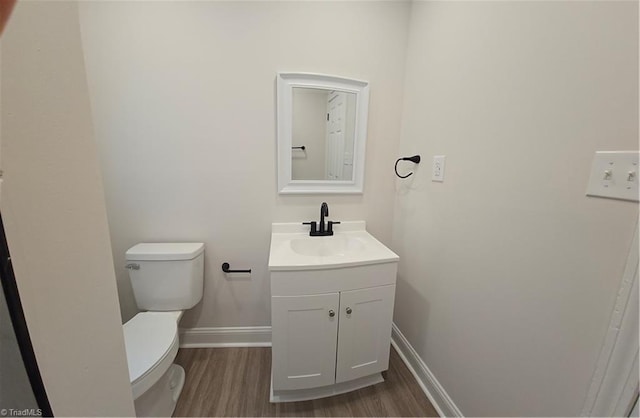 bathroom featuring vanity, wood-type flooring, and toilet