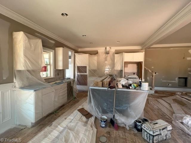 kitchen featuring white cabinetry, ornamental molding, and light hardwood / wood-style floors