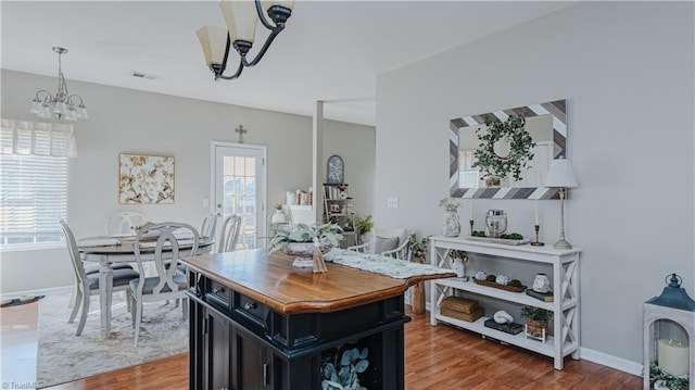 dining room with visible vents, light wood-style flooring, and baseboards