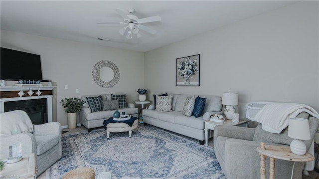 living room with visible vents, a fireplace, and a ceiling fan