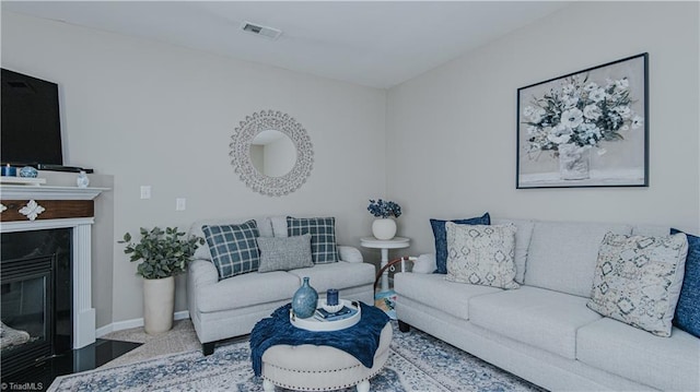 living area with visible vents, baseboards, carpet flooring, and a fireplace