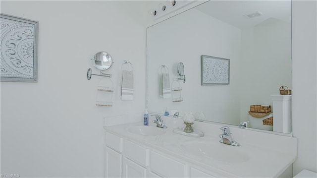 bathroom with double vanity, visible vents, and a sink