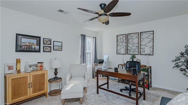 office area with baseboards, a ceiling fan, visible vents, and light carpet