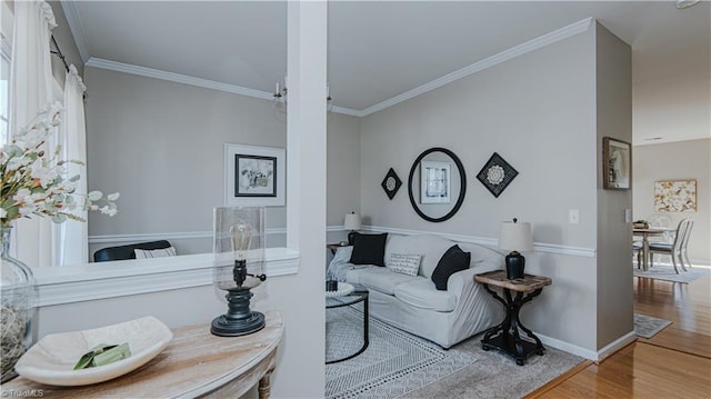 living room with ornamental molding, baseboards, and wood finished floors