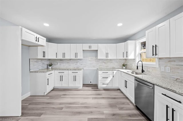 kitchen with dishwasher, light stone countertops, light wood finished floors, and a sink