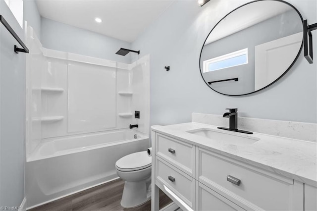 bathroom with toilet, vanity,  shower combination, and wood finished floors