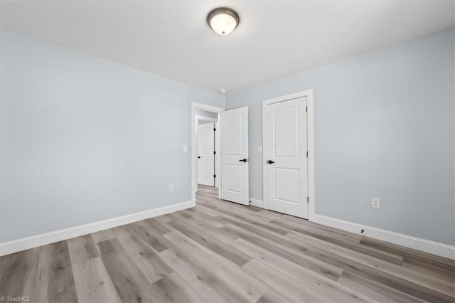 unfurnished bedroom with baseboards and light wood finished floors