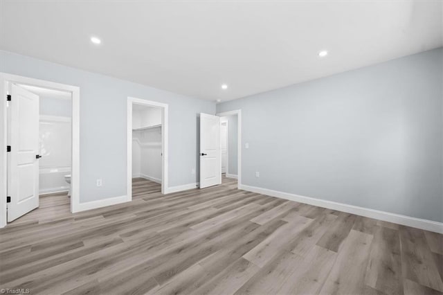 unfurnished bedroom with recessed lighting, light wood-type flooring, and baseboards