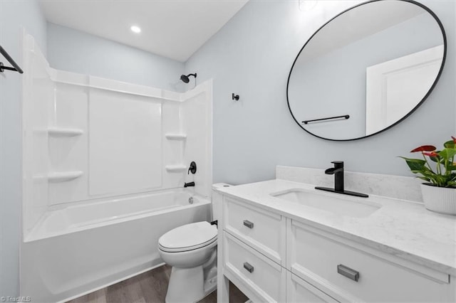 full bathroom with bathing tub / shower combination, toilet, wood finished floors, and vanity