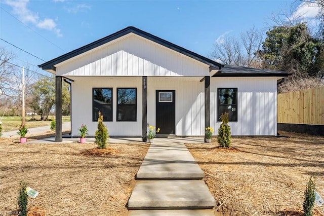 modern farmhouse style home with fence