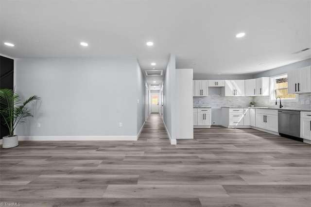 kitchen with baseboards, dishwasher, decorative backsplash, light wood-style floors, and white cabinets