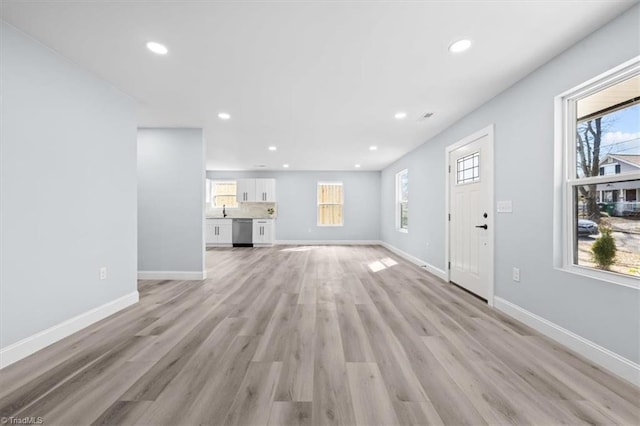 unfurnished living room featuring recessed lighting, baseboards, and light wood-style floors