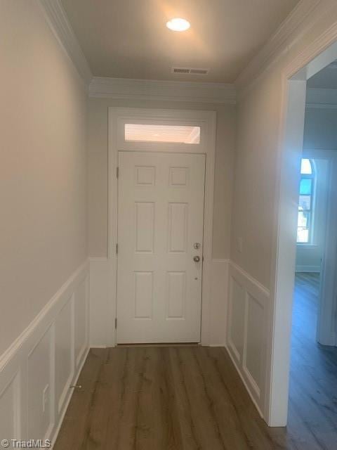 doorway to outside featuring ornamental molding and dark wood-type flooring