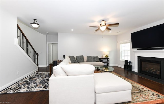 1117 Magenta Way, Kernersville, NC 27284 - living room featuring wood finished floors, a ceiling fan, stairway, baseboards, and a glass covered fireplace