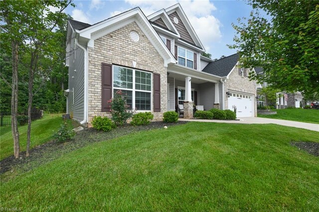 1117 Magenta Way, Kernersville, NC 27284 - craftsman-style home featuring a porch, driveway, a front yard, stone siding, and a garage