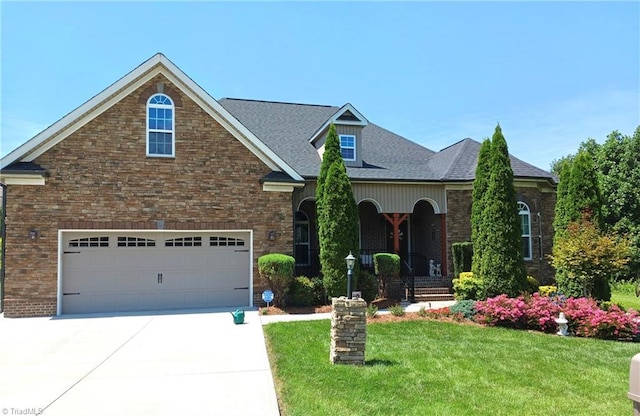 view of front of house with a front lawn, a garage, and a porch