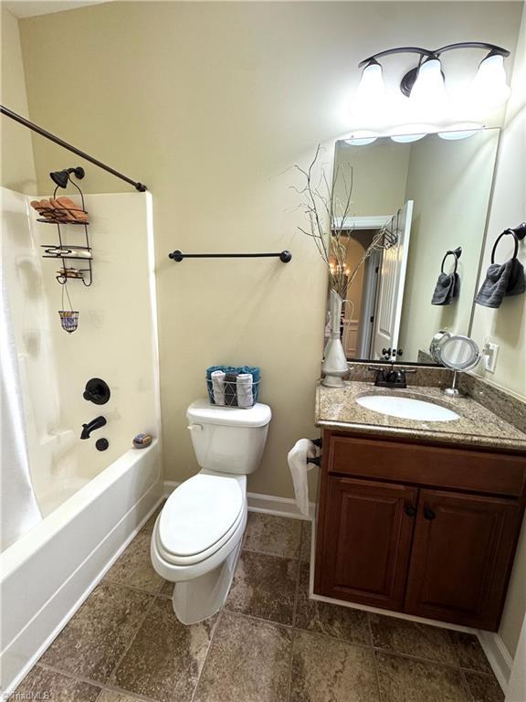 full bathroom with toilet, vanity, and  shower combination