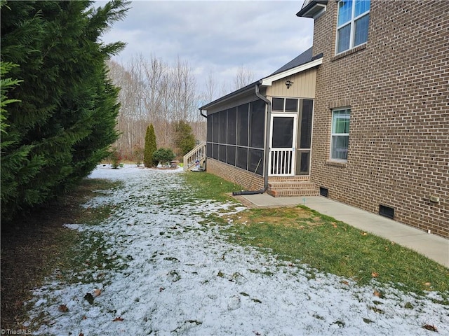 view of snowy exterior featuring a sunroom