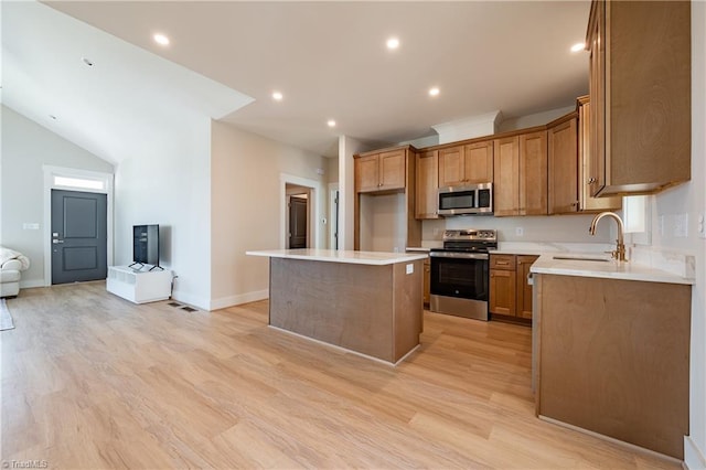 kitchen featuring a kitchen island, light wood-type flooring, recessed lighting, stainless steel appliances, and a sink