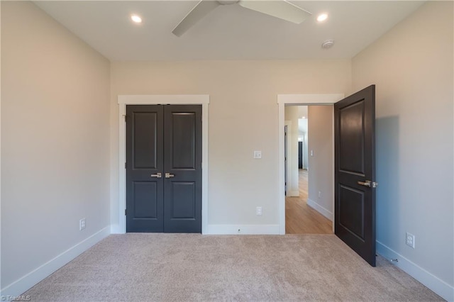 unfurnished bedroom featuring recessed lighting, light colored carpet, baseboards, and a closet