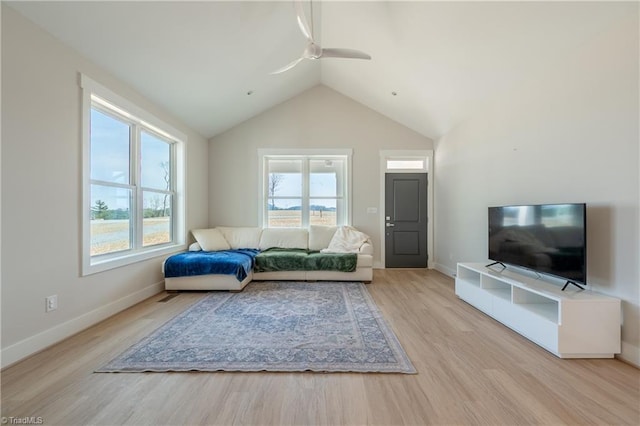 living area featuring wood finished floors, a ceiling fan, baseboards, and lofted ceiling