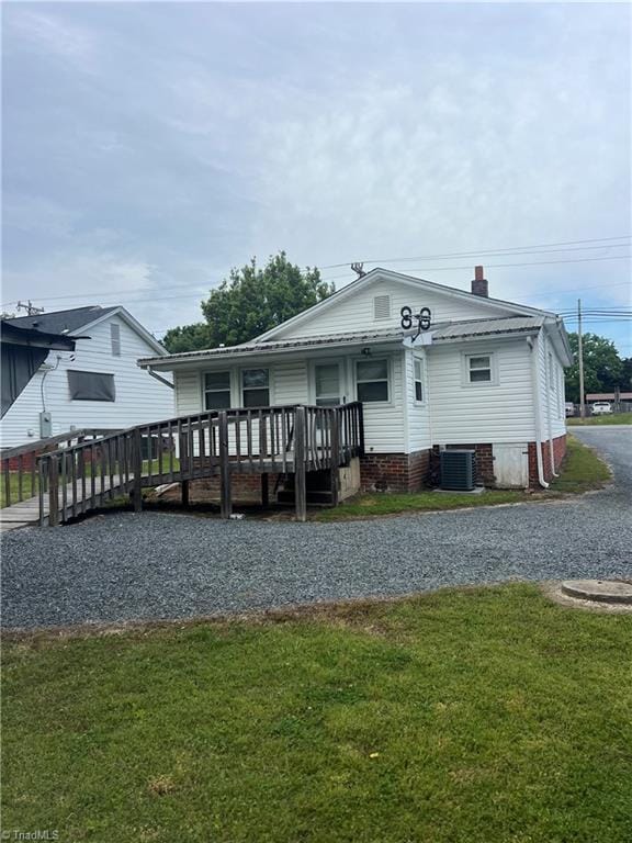 view of front of home featuring a front yard, a chimney, and a deck