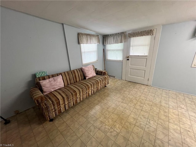 living area featuring tile patterned floors, vaulted ceiling, and baseboard heating