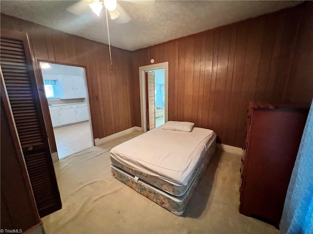 bedroom with carpet, wood walls, a textured ceiling, and ceiling fan