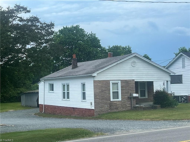 view of property exterior with a chimney, a yard, and central AC unit