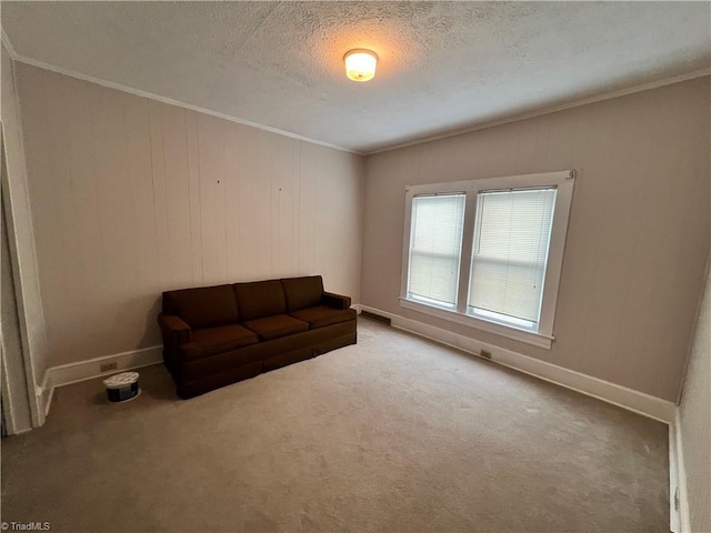 unfurnished room featuring ornamental molding, a textured ceiling, carpet, and baseboards