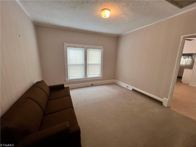 unfurnished room with carpet, ornamental molding, a textured ceiling, and wooden walls