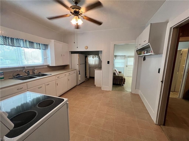 kitchen featuring electric range oven, freestanding refrigerator, white cabinetry, a sink, and ceiling fan