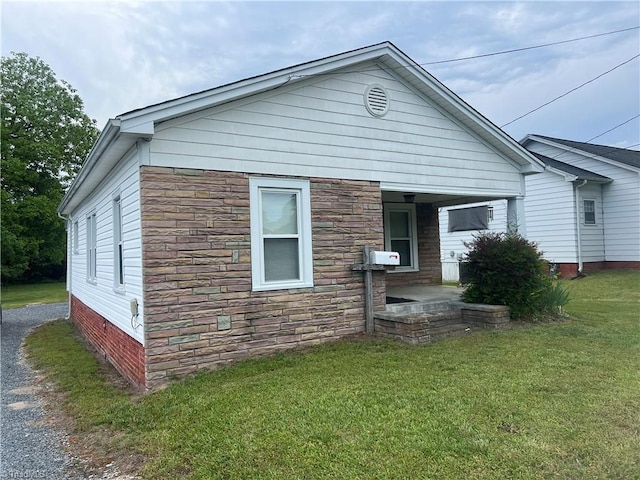 view of front of house featuring stone siding and a front yard