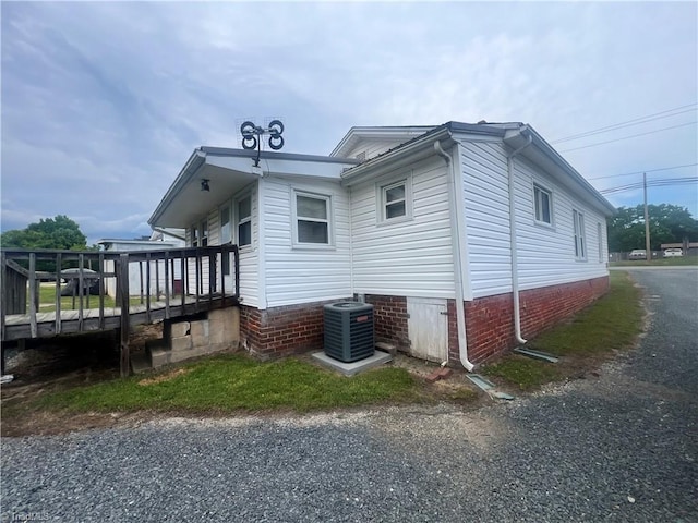 view of property exterior featuring a wooden deck and cooling unit