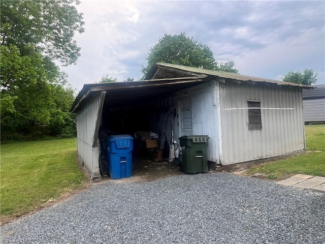 view of outbuilding with gravel driveway and a carport