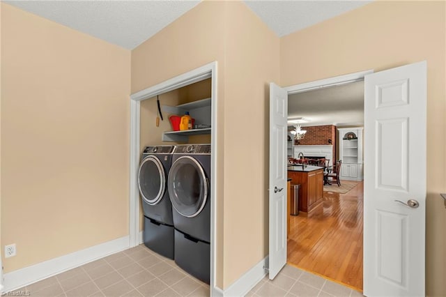 laundry room with laundry area, a sink, baseboards, and independent washer and dryer