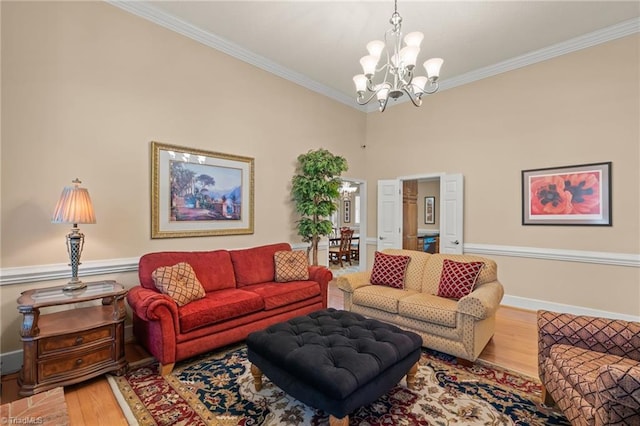 living area featuring baseboards, ornamental molding, wood finished floors, and a chandelier