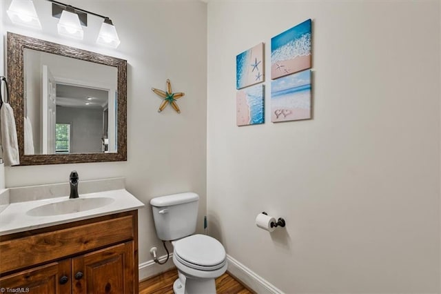 2515 E Woodlyn Way, Greensboro, NC 27407 - half bath with toilet, wood finished floors, baseboards, and vanity