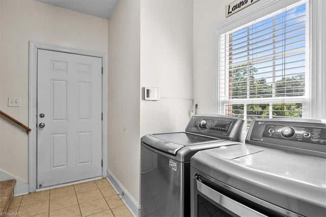 2515 E Woodlyn Way, Greensboro, NC 27407 - laundry room featuring washing machine and clothes dryer, healthy amount of natural light, light tile patterned floors, and baseboards