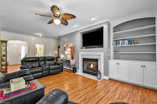 2515 E Woodlyn Way, Greensboro, NC 27407 - living area featuring ornamental molding, a ceiling fan, a fireplace, light wood finished floors, and built in shelves