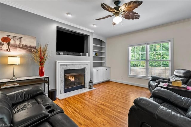 2515 E Woodlyn Way, Greensboro, NC 27407 - living area featuring a ceiling fan, crown molding, light wood finished floors, a premium fireplace, and baseboards