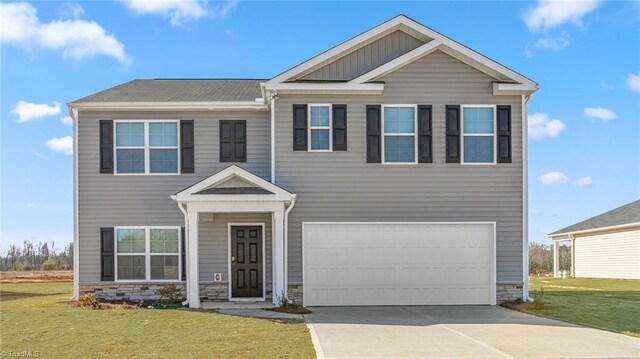144 Rose Wind Way, Mayodan, NC 27027 - view of front facade featuring a garage, stone siding, concrete driveway, and a front lawn