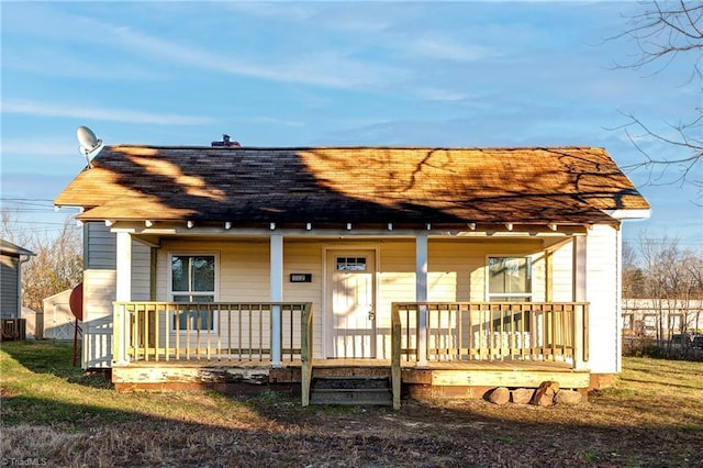 rear view of house featuring central air condition unit and covered porch