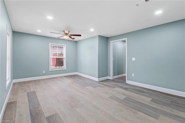 spare room with light hardwood / wood-style flooring, ceiling fan, and a healthy amount of sunlight