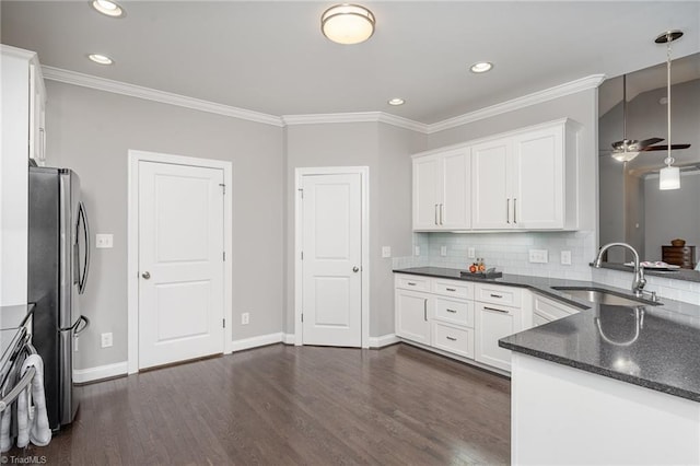 kitchen featuring stainless steel refrigerator, white cabinetry, sink, pendant lighting, and decorative backsplash