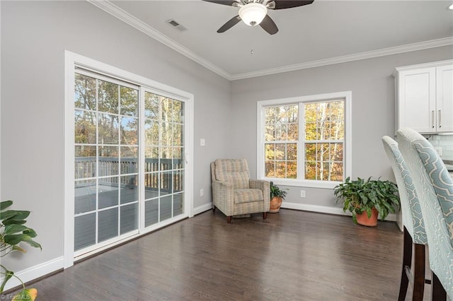 sitting room with ceiling fan, crown molding, and dark wood-type flooring